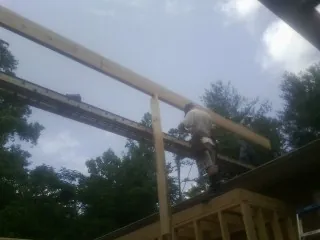 Carpenter setting a ridge beam over a new addition frame — Ice Dam Removal by Roofing Brothers in Mackville