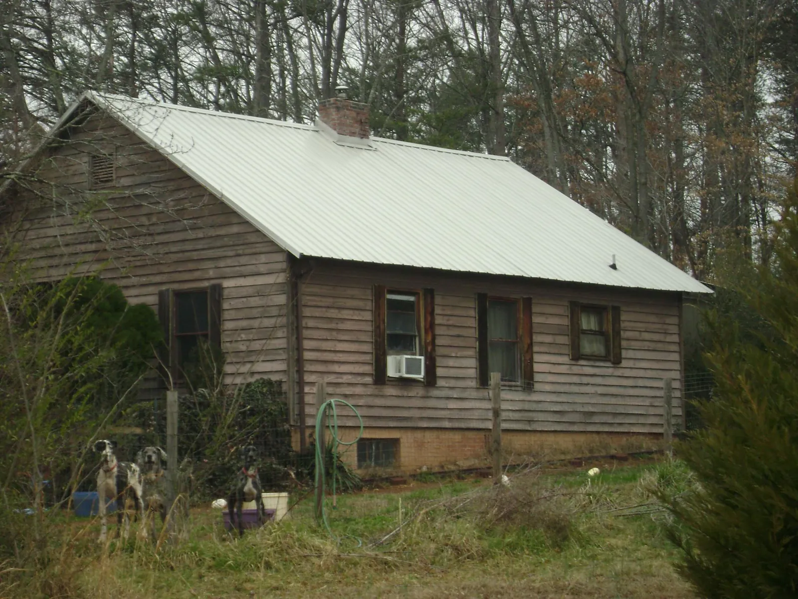 White metal roof on an old wood sided farmhouse, from a Metal Roof Installation job in Mackville