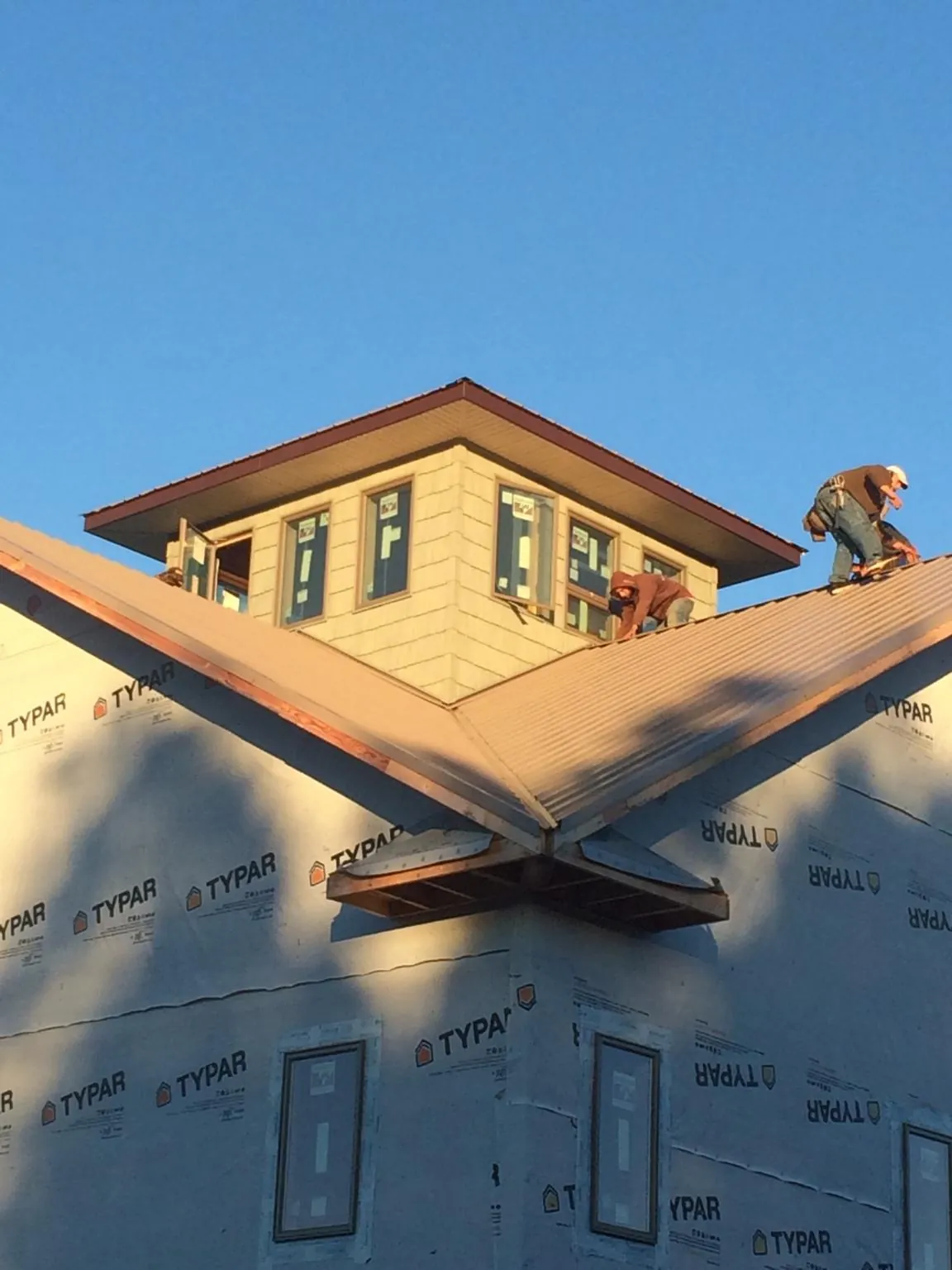 Roofers working around a rooftop cupola on a new metal roof at sunset — Roof Waterproofing in Mackville by Roofing Brothers